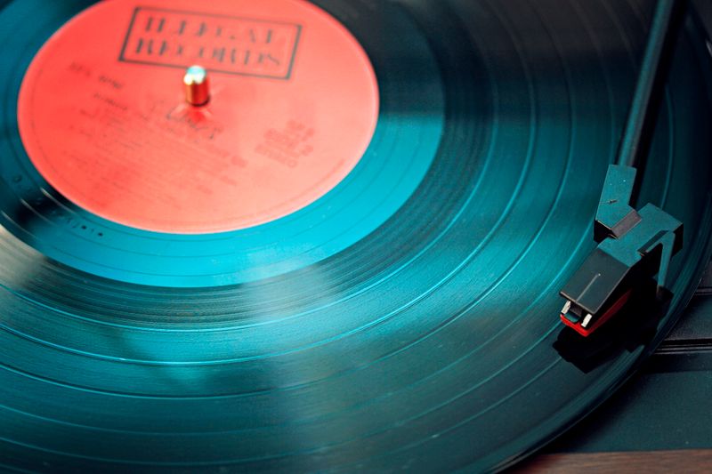 Primer plano de un vinilo negro sobre una bandeja giradiscos con luz cálida